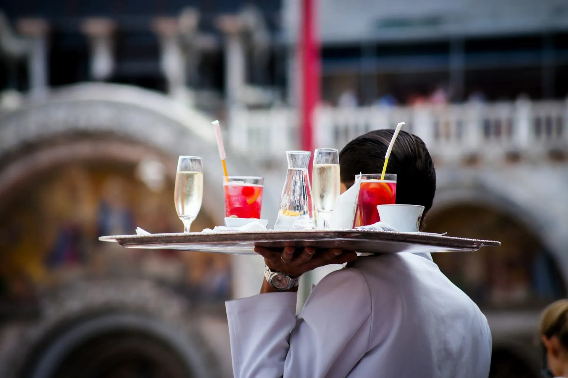 A waiter carrying a tray with cocktails